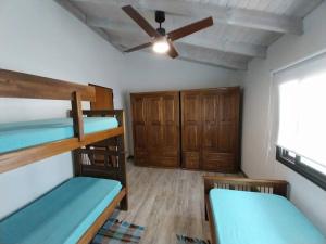 um quarto com 2 beliches e uma ventoinha de tecto em Hospedaje ideal a metros del rio em Los Reartes