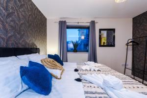 ein Schlafzimmer mit einem großen weißen Bett mit blauen Kissen in der Unterkunft Lovely 2-bed apartment *free parking *pool table in Liverpool