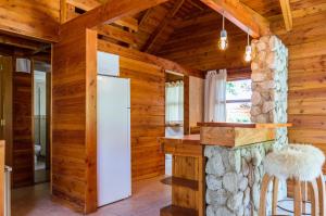 a kitchen with a refrigerator in a log cabin at BOG Jardin de Flores in Villa La Angostura +12 photos