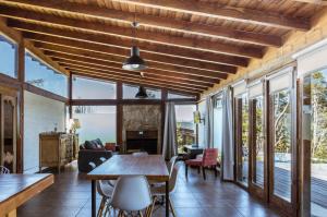 een woonkamer met een houten plafond en een tafel en stoelen bij BOG Dolce Far Niente in Villa La Angostura