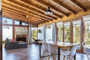 sala de estar con techo de madera, mesa y sillas en BOG Dolce Far Niente en Villa La Angostura