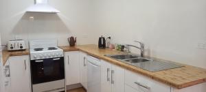 uma cozinha com um lavatório e um fogão em St David's on James Luxury apartments em Dunedin