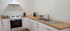 cocina con fregadero y fogones en St David's on James Luxury apartments, en Dunedin