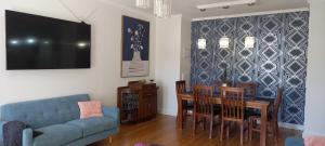 sala de estar con sofá azul, mesa y sillas en St David's on James Luxury apartments, en Dunedin