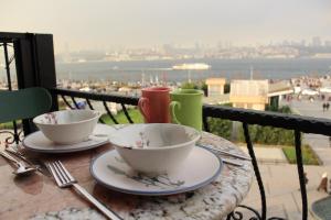 a table with two cups and plates on a balcony at Suit Üsküdar in Istanbul