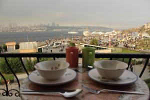 una mesa con 2 tazas y platos en un balcón en Suit Üsküdar, en Estambul