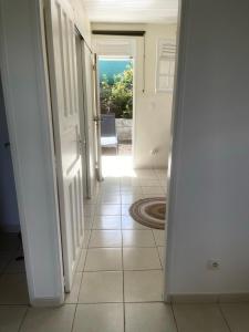 a hallway with an open door and a tile floor at ALIZÉ CAP in Sainte-Anne