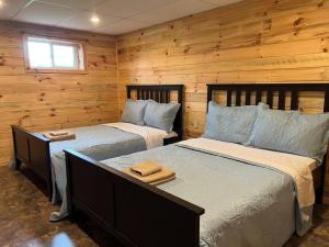 due letti in una stanza con pareti in legno di Family friendly cottage ☆walking distance to beach a Lion's Head