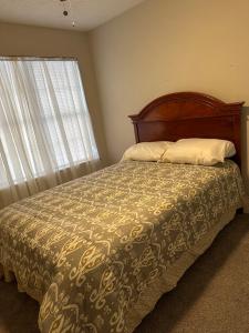 a bedroom with a bed with a bedspread and a window at Cozy - Home Away From Home with Free Parking in Atlanta