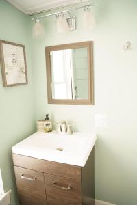 uma casa de banho com um lavatório e um espelho em The Kelly House - 4 BR Historic Lodge - Downtown em Ellicottville