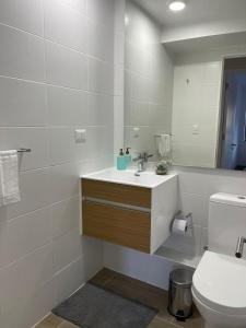 La salle de bains est pourvue d'un lavabo, de toilettes et d'un miroir. dans l'établissement Puerto Montt apartamento en playa Pelluco, à Puerto Montt