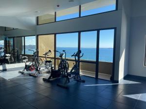 einen Fitnessraum mit Kardiogeräten und Meerblick in der Unterkunft Puerto Montt apartamento en playa Pelluco in Puerto Montt