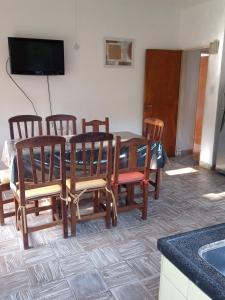 comedor con mesa, sillas y TV en Córdoba - La Cumbre -Casa Temporario -Vista Cristo en La Cumbre