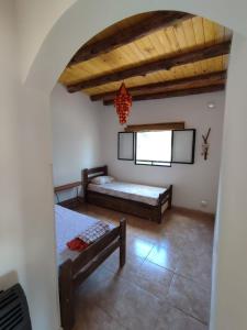 1 dormitorio con 2 camas y techo en Saucearriba, Saucelinda. en Villa Dolores
