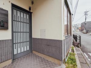 een toegang tot een gebouw met een deur bij Spacious One Room Apartment for up to 5ppl w Kitchenette in Kumamoto