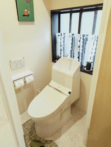 熊本的住宿－Spacious One Room Apartment for up to 5ppl w Kitchenette，一间带白色卫生间的浴室和窗户。