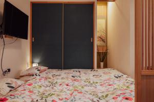 a bedroom with a large bed with a large window at Spacious One Room Apartment for up to 5ppl w Kitchenette in Kumamoto