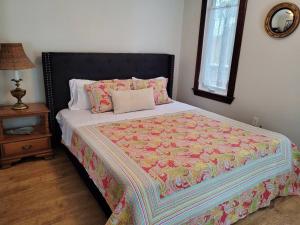 ein Bett mit einer Decke in einem Schlafzimmer in der Unterkunft Rustic Pines Waterfront Cottage *CLEAR WATER* in Fenelon Falls