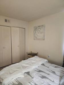 a white bed in a bedroom with white walls at Lovely 2 Bedroom Condo with Pool in Chapel Hill