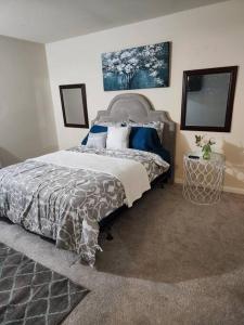 a bedroom with a large bed with blue pillows at Lovely 2 Bedroom Condo with Pool in Chapel Hill