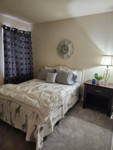 1 dormitorio con 1 cama y 1 mesa con lámpara en Lovely 2 Bedroom Condo with Pool, en Chapel Hill