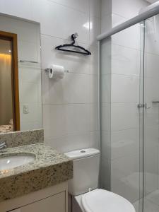 La salle de bains est pourvue de toilettes, d'un lavabo et d'une douche. dans l'établissement Condomínio Everest Flat, à Caldas Novas