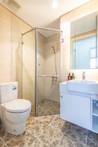 een badkamer met een douche, een toilet en een wastafel bij Vinhomes D'Capitale 2-bed apartment with Sunset view in Hanoi