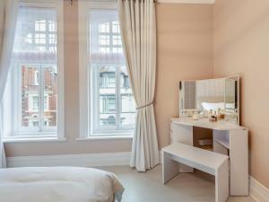 a bedroom with a mirror and a bed and window at Beach Town in Bournemouth