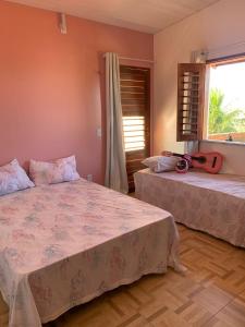 um quarto com 2 camas e uma janela em Happy Hostel e Pousada Paracuru em Paracuru