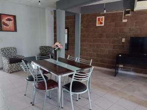 Un comedor con mesa y sillas y un televisor. en Complejo Navi, en Mina Clavero