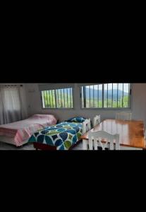 巴耶埃爾莫索的住宿－El Despertar，一间卧室设有两张床、一张桌子和窗户。