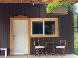 a house with two chairs and a door at Battle Creek Ranch, Wells Gray Park in Clearwater