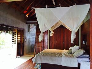 a bedroom with a bed with a net canopy at Kooyu Villas in Port Vila