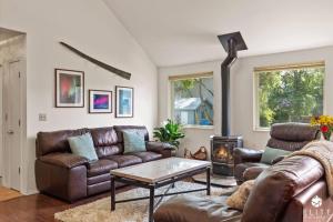 a living room with a leather couch and a fireplace at Lavish 5 Star Modern Villa BEST Location in DOWNTOWN in Anchorage