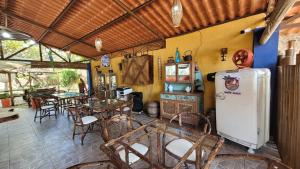 a dining room with a table and a refrigerator at Pousada Beach Bahia in Porto Seguro