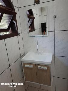 a bathroom with a sink and a mirror at Chácara Vicente Gazzi in Socorro