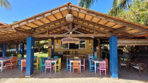 a restaurant with tables and chairs under a wooden pergola at Pousada Beach Bahia in Porto Seguro