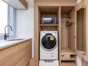 a kitchen with a washing machine and a microwave at Tokyu Stay Shibuya Shin-Minamiguchi in Tokyo