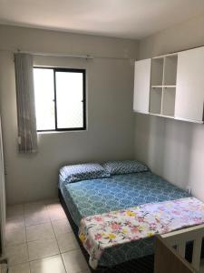 a bedroom with a bed in a room with a window at Verão on in Cabedelo