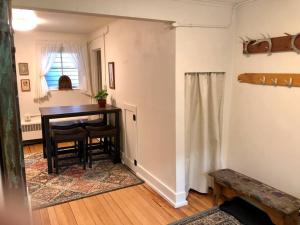 a dining room with a table and a room with a window at 1915 Coastal Historical Log Home #1 Spot Downtown! in Anchorage