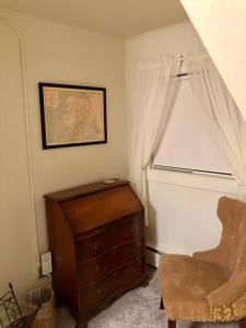 a room with a chair and a dresser and a window at 1915 Coastal Historical Log Home #1 Spot Downtown! in Anchorage