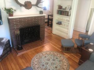 a living room with a fireplace and a couch and chairs at 1915 Coastal Historical Log Home #1 Spot Downtown! in Anchorage