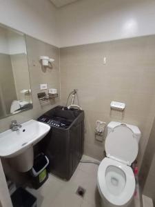 a bathroom with a white toilet and a sink at Shore Residences in Manila