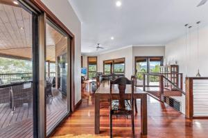 a dining room with a table and a balcony at Seascape Paradise in Airlie Beach