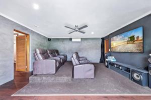 a living room with two chairs and a flat screen tv at Seascape Paradise in Airlie Beach