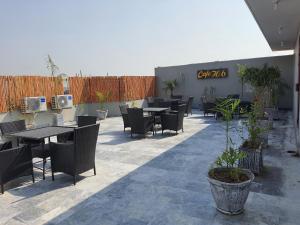 a patio with tables and chairs and a fence at Hotel H6 in Rawalpindi