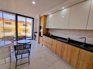 a kitchen with two chairs and a table in it at Praia Modern Apartment vista Mar in Praia