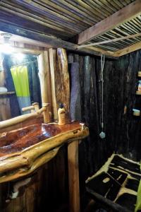 a bathroom with a wooden sink and a mirror at Natty Tropical Valley in Roseau