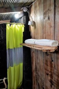 a bathroom with a shower with a green curtain at Natty Tropical Valley in Roseau