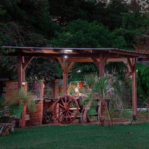 a wooden gazebo with a wooden wagon under it at Cabañas Mama Rosa in Puerto Iguazú